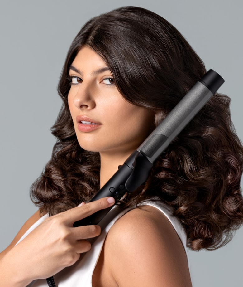 ヘアアイロンを使用している女性